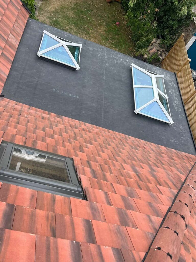 This is a photo taken from the roof ridge looking down a tiled pitched roof on to a flat roof. Works carried out by LS Roofing Marlow